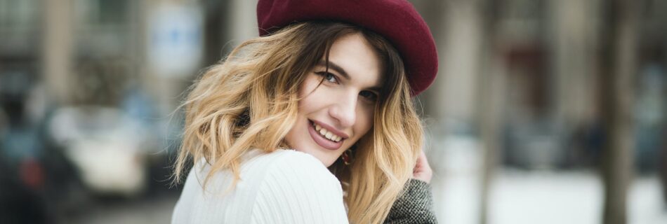 selective focus photography of smiling woman wearing red hat during snowy day